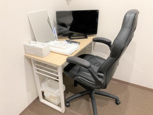 a desk with a chair and a computer on it at Tabist Tatebayashi Station Hotel in Tatebayashi