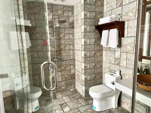 uma casa de banho com um chuveiro, um WC e um lavatório. em Zhangjiajie Memory Inn em Zhangjiajie