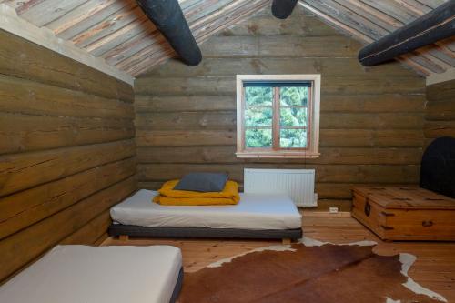 pokój z 2 łóżkami i oknem w drewnianym pokoju w obiekcie Villa Trötvik, in the deep forest of Värmland w mieście Gräsmark