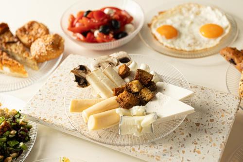 Nir David Country Lodge في نير داويد: طاولة مليئة بأطباق من الجبن والأطعمة الأخرى