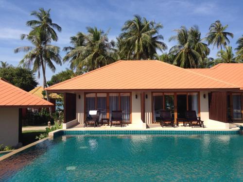 a villa with a swimming pool and palm trees at Blue Bay Resort in Ko Yao Yai
