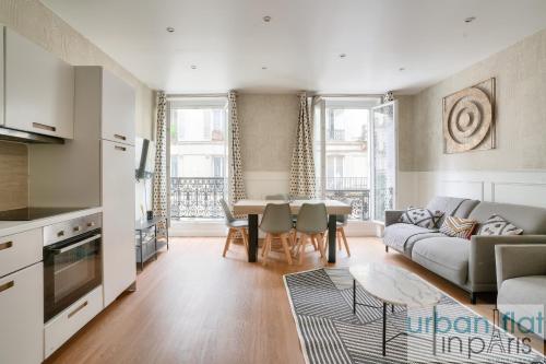 une cuisine et un salon avec un canapé et une table dans l'établissement 23 - Charming 3BDR Parisian Apartment in Montorgueil, à Paris
