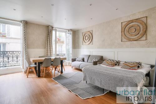 un salon avec deux lits et une table dans l'établissement 23 - Charming 3BDR Parisian Apartment in Montorgueil, à Paris