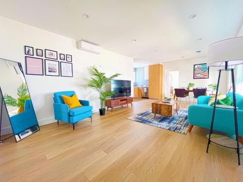 a living room with two blue chairs and a television at Hollywood/Thai Town Courtyard Apartment in Los Angeles