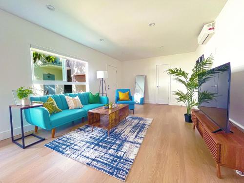 a living room with a blue couch and a table at Hollywood/Thai Town Courtyard Apartment in Los Angeles