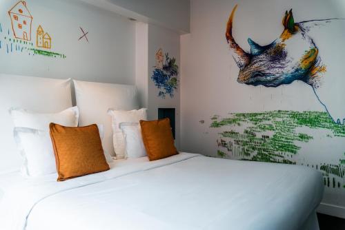 a bedroom with a white bed and a painting of a cow at 1K Paris in Paris