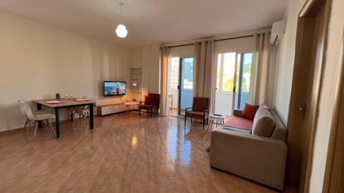 a living room with a couch and a table and chairs at Marina Apartment in Durrës