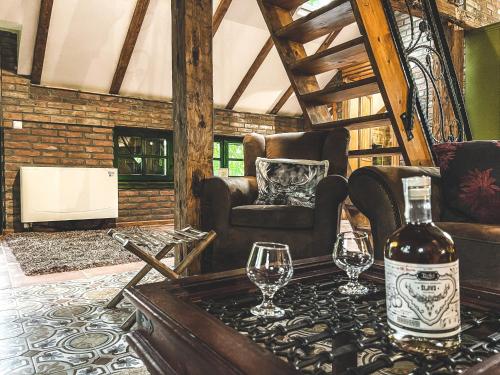a bottle of wine on a table with two glasses at Wood Mood Apartman Tiganjica in Staji°evo