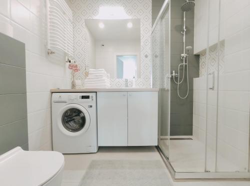 a white bathroom with a washing machine in it at Dobrego Pasterza 120D by Homeprime in Kraków