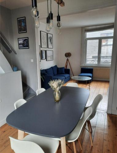 een eetkamer met een zwarte tafel en stoelen bij Charmante maison 3 chambres avec cour in Lille