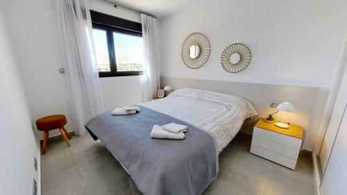 1 dormitorio con cama y espejo en la pared en Amazing 2 Bed 2 Bath Apartment Los Dolses, en Orihuela Costa