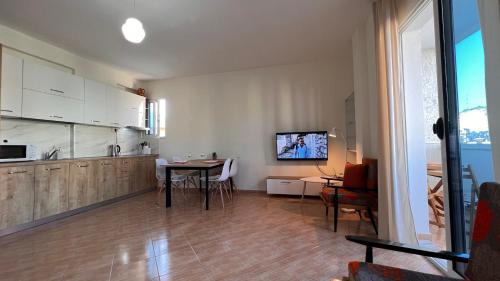 a kitchen and dining room with a table and a tv at Marina Apartment in Durrës