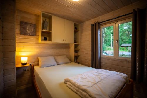 una camera con un letto in una cabina di legno di Chalet de bosuil a Zutendaal