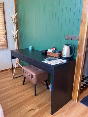 a black desk with a chair in a room at แคมป์คาฟ จันทบุรี ( Kamp Kaff) in Ban Khlong Som (1)