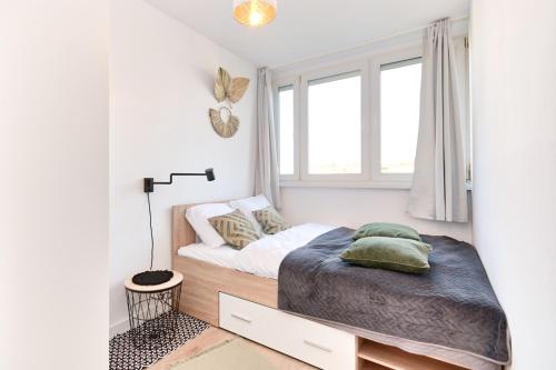 a small bedroom with a bed and a window at Olive City View Apartment in Wrocław