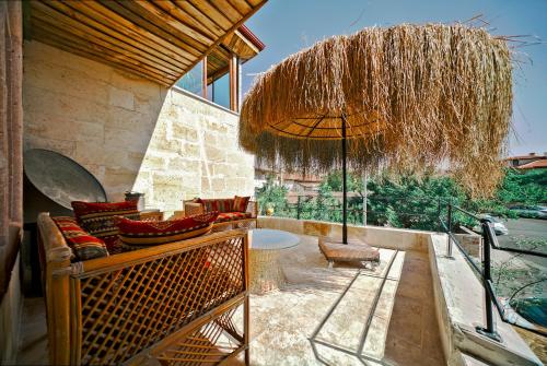 a patio with a couch and an umbrella at Aysel Inn House in Goreme