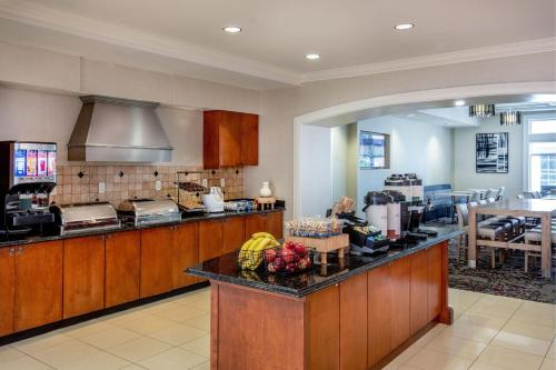 a kitchen with wooden cabinets and a counter top at Residence Inn by Marriott Chesapeake Greenbrier in Chesapeake