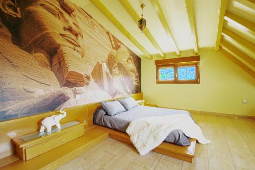 a bedroom with a large painting on the wall at Green House in Reocín
