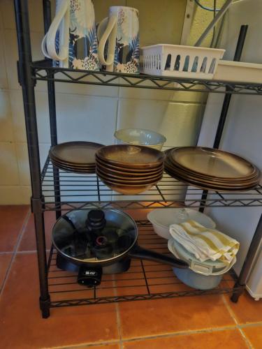 a shelf with plates and bowls and dishes on it at Di's B&B in Matamata