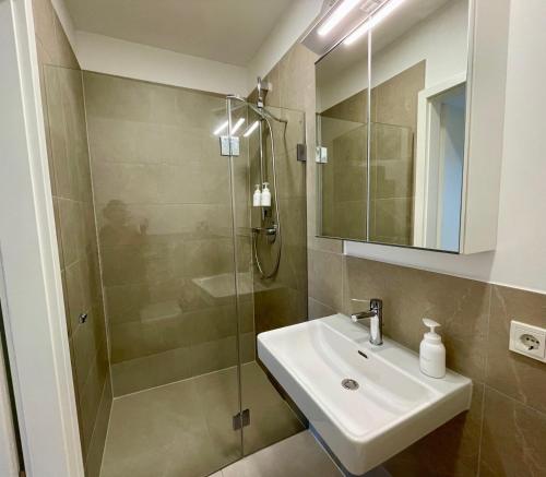W łazience znajduje się umywalka i prysznic. w obiekcie Condo Apartments Hamburg w mieście Hamburg
