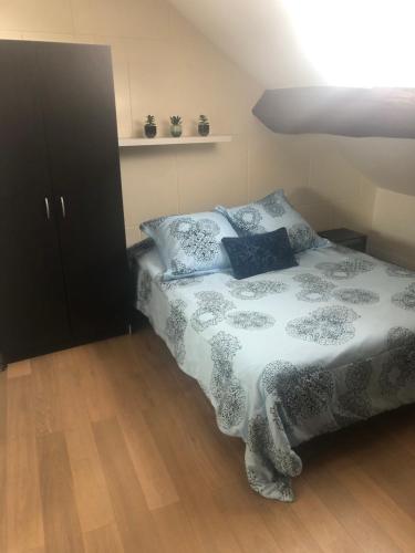 une chambre avec un lit avec des draps bleus et blancs dans l'établissement Appartement Montevrain, à Montévrain