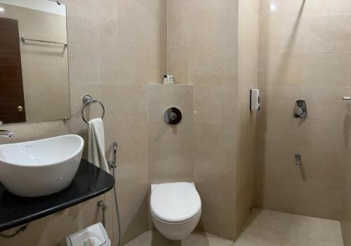 a bathroom with a white toilet and a sink at SeaScape Port Blair in Port Blair
