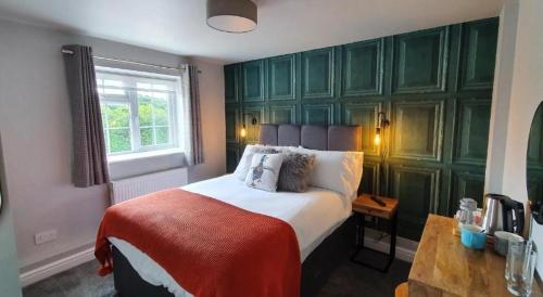 a bedroom with a large bed with green walls at The George Country Inn, Wath in Wath