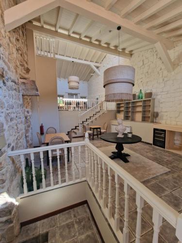 cocina y sala de estar con escalera y mesa en Maison Barón de la Galleta B&B en Quintanilla las Torres