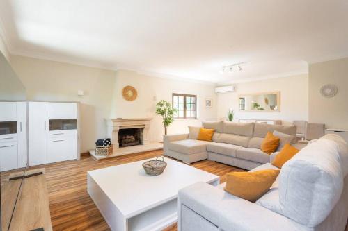 a living room with a couch and a table at Aroeira Sunny Villa - Heated Pool extra cost in Amora
