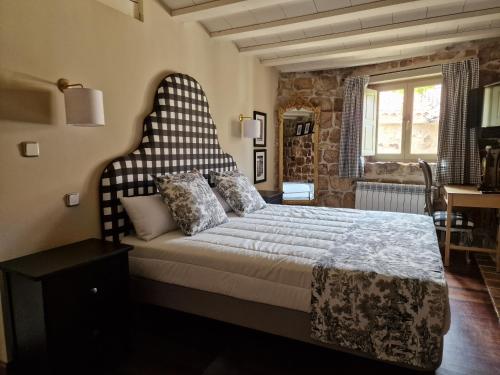 1 dormitorio con 1 cama grande y cabecero grande en Maison Barón de la Galleta B&B en Quintanilla las Torres