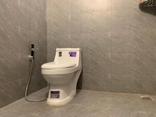 a bathroom with a toilet in a tiled wall at Villa Martial Arts Gym & Guesthouse in Phnom Penh