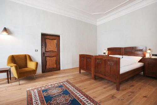 ein Schlafzimmer mit einem Bett, einem Stuhl und einem Tisch in der Unterkunft Ansitz Layshof Apartment Erlebach in Meran