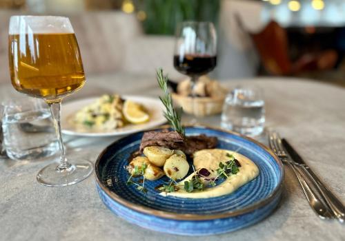 a table with a plate of food and a glass of wine at Best Western Plus Sthlm Bromma in Stockholm
