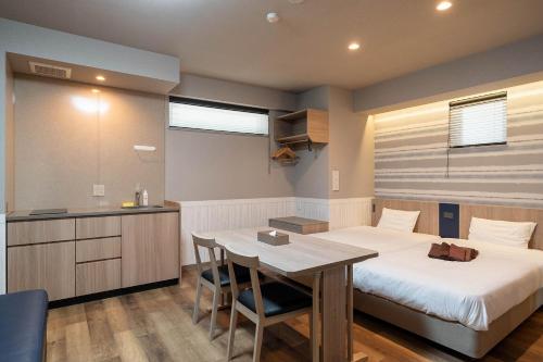 - une chambre avec un lit, une table et un bureau dans l'établissement stayme THE HOTEL Ueno, à Tokyo