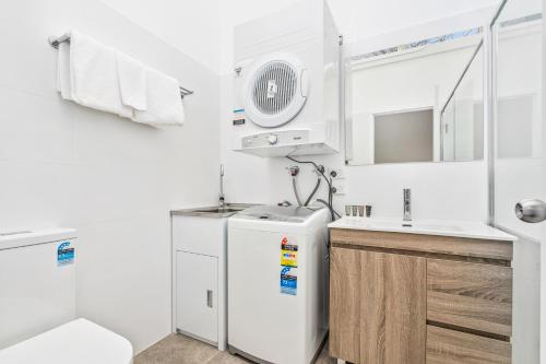 a small kitchen with a refrigerator and a sink at APX Parramatta in Sydney