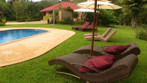 a group of chairs and an umbrella next to a pool at Cliffside Lagoon Villa in Ao Nang Beach