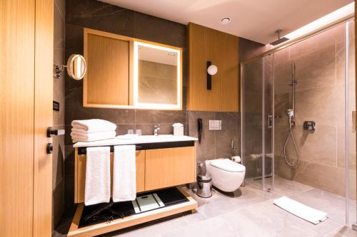 W łazience znajduje się umywalka, toaleta i prysznic. w obiekcie Avrupa Residence Suites w Stambule