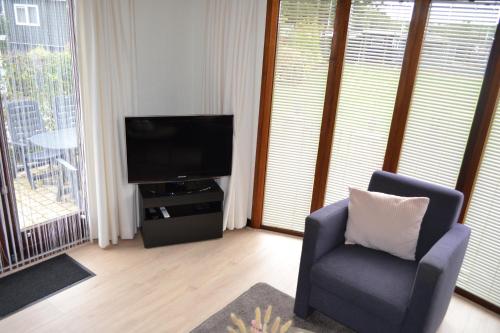 安盧的住宿－De Specht，客厅配有电视和椅子