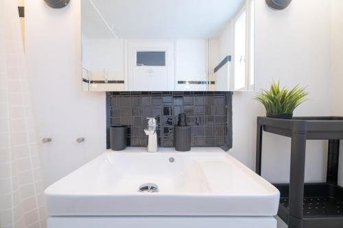 a bathroom with a white sink and a black tile wall at Athens armonia 2 bedrooms 4 pers. apartment by MPS in Athens