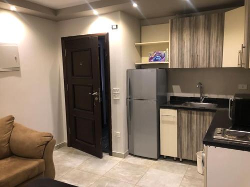 a kitchen with a black door and a refrigerator at Lovely studio in the heart of heliopolis, cairo in Cairo