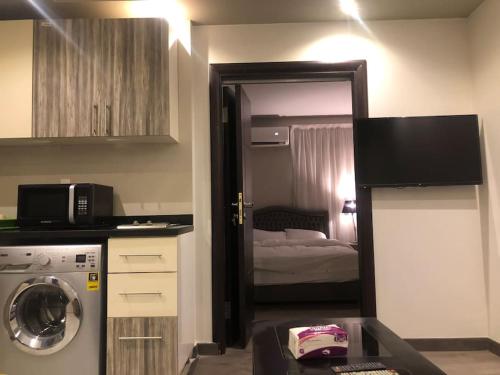 a small room with a kitchen with a washing machine at Lovely studio in the heart of heliopolis, cairo in Cairo