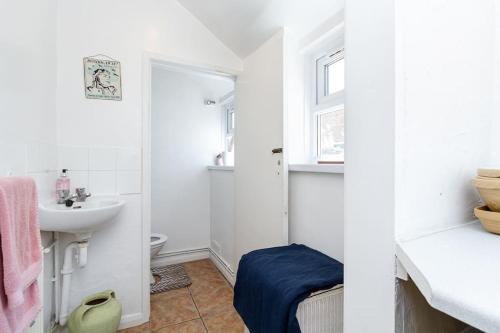 uma casa de banho branca com um lavatório e um WC em Beautiful Townhouse, great location - Pet Friendly em Cardiff