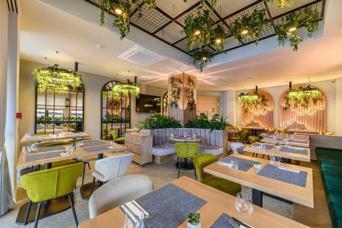 um restaurante com mesas de madeira e cadeiras verdes em Hotel DUKAT em Gura Humorului