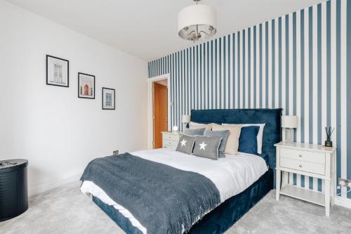 a bedroom with a blue and white striped wall at Chic 1 Bed Flat Zone 2 Hampstead Swiss Cottage in London