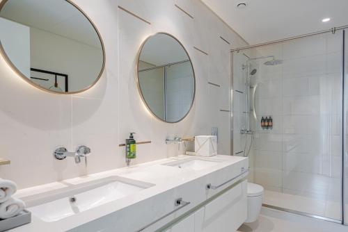een badkamer met een wastafel, een toilet en een spiegel bij CitiHome-3BR Marina with beach view in Dubai