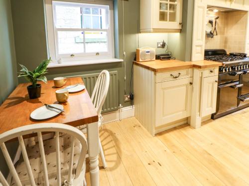 a kitchen with a wooden table and a table and chairs at Chapel Cottage in Barnard Castle