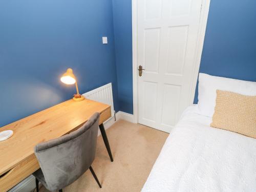 a bedroom with a desk and a bed and a table and chair at Chapel Cottage in Barnard Castle