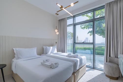 een slaapkamer met een groot bed en een groot raam bij CitiHome-3BR Marina with beach view in Dubai