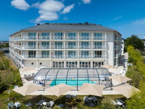 una vista aérea de un hotel con piscina y sombrillas en Golden Tulip La Baule, en La Baule