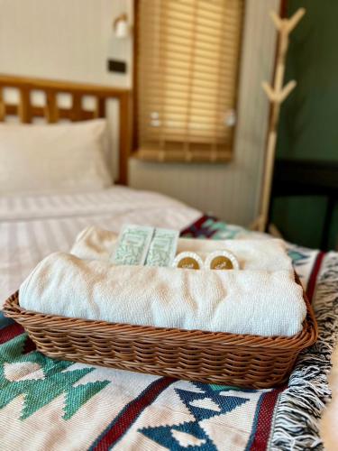 a basket with two towels on top of a bed at แคมป์คาฟ จันทบุรี ( Kamp Kaff) in Ban Khlong Som (1)